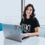 smiling woman looking up from laptop
