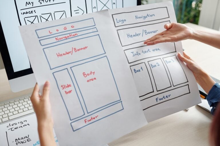 Designer comparing two versions of a website wireframe.