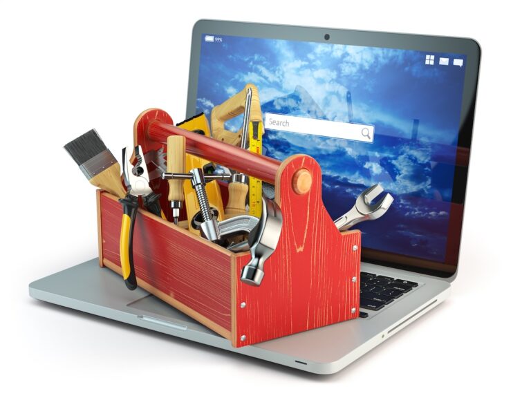 Toolbox full of tools sitting on an open laptop.