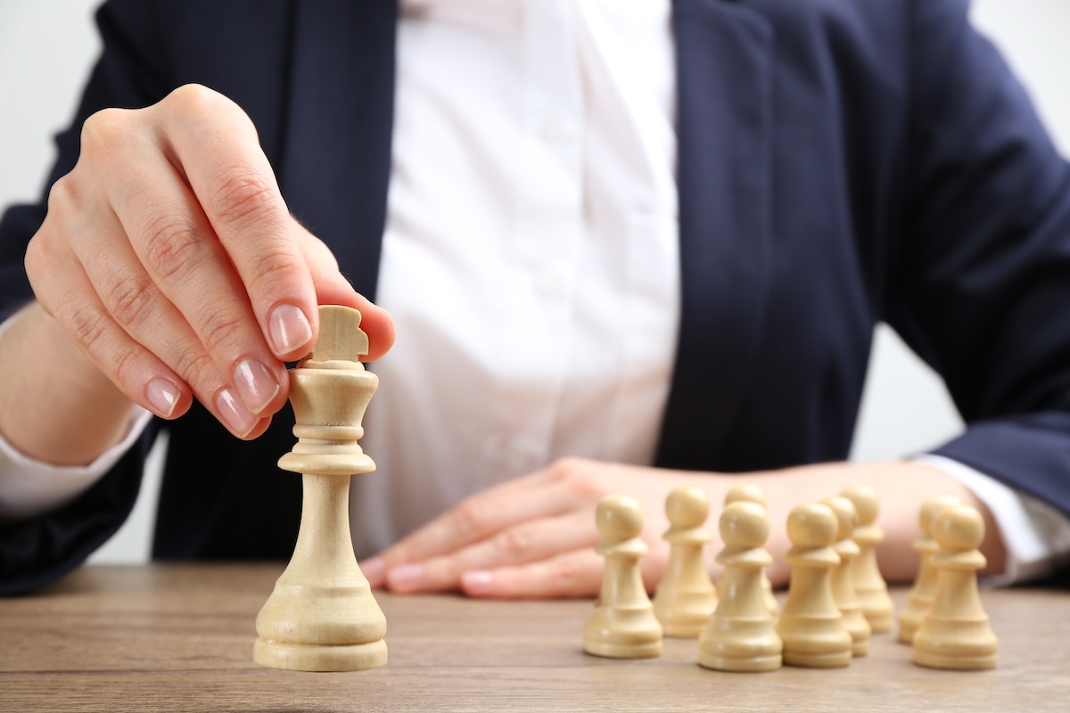 Closeup of woman moving a chess piece