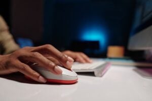 Closeup of hands using a mouse and keyboard on a desk